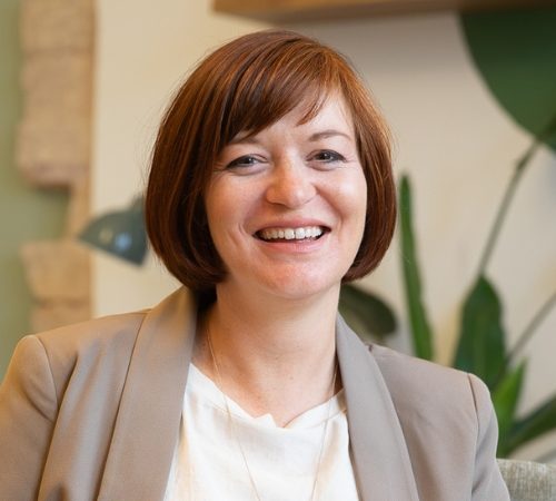 Porträtfoto Birgit Gebauer (Eva Korn) Birgit Gebauer, Psychologin, lächelt, trägt einen beigen Blazer, systemisches Coaching.